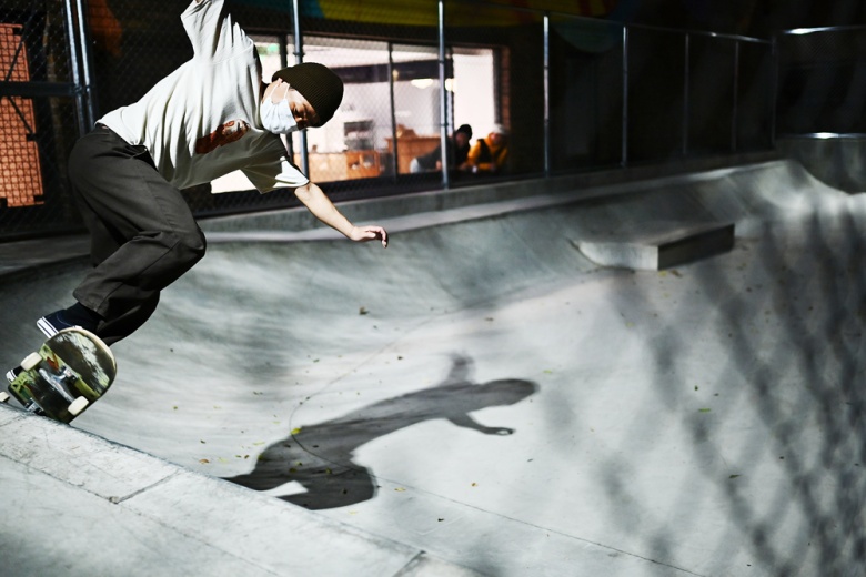 Skateboarder shredding with a face mask