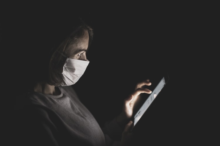 Woman with face mask using a smart phone